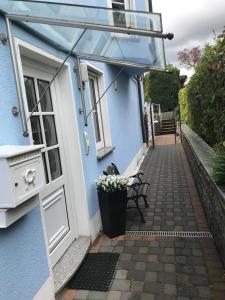 ein blaues Haus mit einer weißen Tür und einer Bank in der Unterkunft Blue House Mosel in Piesport