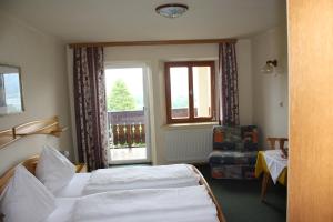 ein Hotelzimmer mit 2 Betten und einem Fenster in der Unterkunft Haus Rosenauer Zimmer & Ferienwohnungen in Nussdorf am Attersee