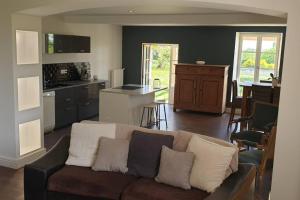 a living room with a couch and a kitchen at Maison de charme au coeur du Sud Ouest in Laplume