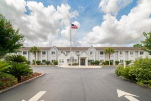 Un grande edificio bianco con una bandiera americana in cima di Microtel Inn & Suites by Wyndham Savannah/Pooler a Savannah