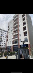 Daily Apartment Tirana في تيرانا: مبنى شقق كبيره امامه لافته