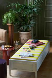 una mesa de centro con una manta amarilla y blanca. en Maison du Val - Les Maisons de Campagne, en Saint-Germain-en-Laye