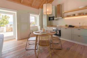 cocina con mesa y sillas en una habitación en Walnut Cottage - Cosiness between hills and sea., en Nafarros