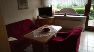sala de estar con sofá rojo y mesa en Ferienwohnung Führing, 