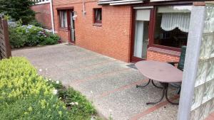 un patio con una mesa y un banco frente a un edificio en Ferienwohnung Führing, 