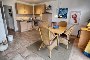 - une cuisine et une salle à manger avec une table et des chaises dans l'établissement Residenz "Am Strand", Whg 8, à Zingst