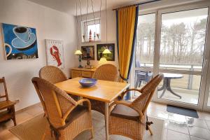 a dining room with a table and chairs and a window at Residenz "Am Strand", Whg 8 in Zingst