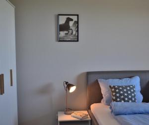 a bedroom with a bed and a table with a lamp at Fehmarnstrand 77 Whg 5 in Staberdorf