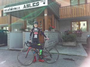 a man standing next to a bike in front of a building at Residence Ables in Valfurva