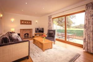 un salon avec un canapé et une cheminée dans l'établissement Riverbank Cottage - idyllic riverside country cottage on South Downs, à Alfriston