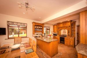 a large kitchen with wooden cabinets and a large island at Riverbank Cottage - idyllic riverside country cottage on South Downs in Alfriston