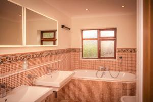 une salle de bain avec deux lavabos et une baignoire dans l'établissement Riverbank Cottage - idyllic riverside country cottage on South Downs, à Alfriston 29 autres photos