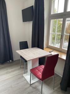 mesa y sillas en una habitación con ventana en Haus zur Eiche Private 1 Zimmerstudios, en Chur