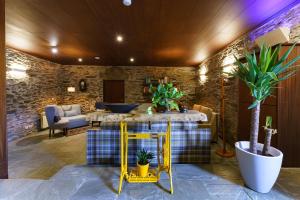 ein Wohnzimmer mit einem gelben Tisch und Pflanzen in der Unterkunft Lar da Mota Boutique Hotel in Arzúa