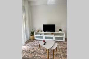 een woonkamer met een tv en een witte kast bij Holiday apartment in Salou