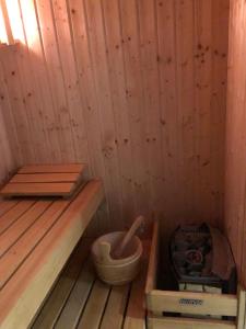 uma sauna de madeira com uma banheira de madeira e um balde em Chałupa łowicka z XIX wieku em Zduny