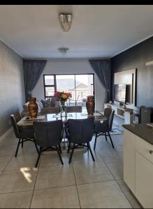 een keuken en een woonkamer met een tafel en stoelen bij Polofields La Bonne Vie in Midrand