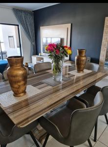 uma mesa de jantar com vasos e flores em Polofields La Bonne Vie em Midrand