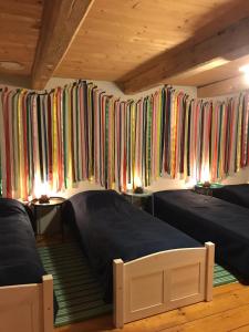 2 łóżka w pokoju z kolorowymi zasłonami w obiekcie Chałupa łowicka z XIX wieku w mieście Zduny