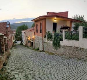 a cobblestone street in front of a house at Guest House Anuki in Sighnaghi