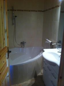 a bathroom with a bath tub and a sink at Les Gîtes du Cairn in Vernamiège