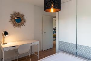 - une chambre avec un bureau et un miroir dans l'établissement THIERS #16 - Appart avec terrasse - 1 Chambre, à Brive-la-Gaillarde