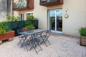 une table et des chaises devant un bâtiment dans l'établissement THIERS #16 - Appart avec terrasse - 1 Chambre, à Brive-la-Gaillarde