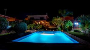 a swimming pool in front of a house at night at Villa Paquita - Delta de l'Ebre in Deltebre