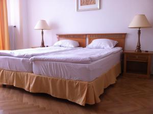 a bedroom with two beds with white sheets and two lamps at Budapest Flat Rent in Budapest