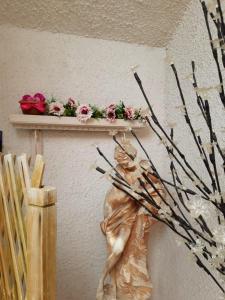 een standbeeld van een vrouw op een plank met bloemen bij B&B La Stella in Manfredonia