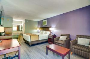 pokój hotelowy z łóżkiem i 2 krzesłami w obiekcie Budget Inn Top of Ellijay w mieście Ellijay