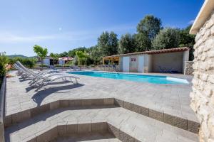 une terrasse avec une piscine et des chaises longues dans l'établissement Les Prairies de l'Encrême, à Céreste