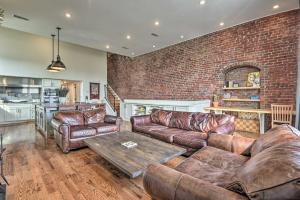 a living room with leather furniture and a brick wall at Modern Knoxville Gem Near Campus and Eateries! in Knoxville