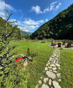 a garden with a tree and a stone path at DREAM RIVER EXCLUSIVE BUNGALOW in Çamlıhemşin