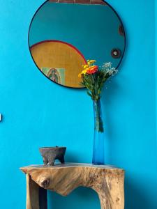 a vase of flowers on a table with a mirror at Departamento Chepe in Sayulita +6 photos