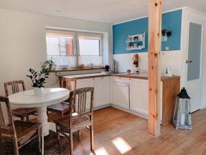 eine Küche mit einem Tisch und einem Tisch und Stühlen in der Unterkunft Charzykówka Domek na Kaszubach in Charzykowy + 15 Fotos