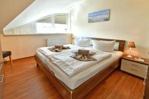 una camera da letto con un letto e asciugamani di Haus Strandmuschel a Zingst