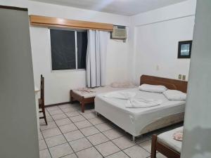 um quarto com 2 camas e uma janela em HOTEL VISUAL em Balneário Camboriú