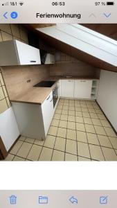 eine kleine Küche mit weißen Schränken und Fliesenboden in der Unterkunft Ferienwohnung im Herzen Allgäu in Altusried