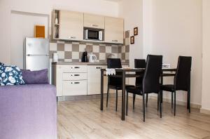 una cucina e una sala da pranzo con tavolo e sedie di Corte dell'Ulivo a San Giuliano Terme