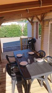 a black table on a deck with black chairs at Camping Le Montourey in Fréjus