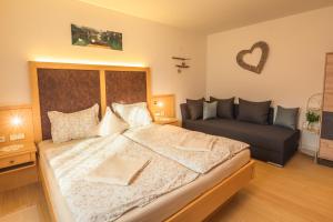 a bedroom with a large bed and a couch at Appartement Stadler in Bad Hofgastein
