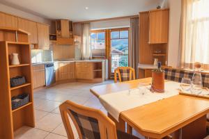 uma cozinha com uma mesa de madeira e uma sala de jantar em Appartement Stadler em Bad Hofgastein