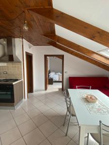 a kitchen and living room with a red couch and a table at La casetta del borgo in Agerola
