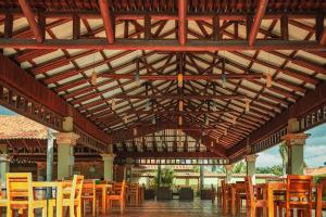 um grande pavilhão de madeira com mesas e cadeiras de madeira em Hotel Paloverde Villas Campestres em Villavicencio