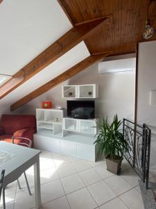 a living room with white furniture and a wooden ceiling at La casetta del borgo in Agerola