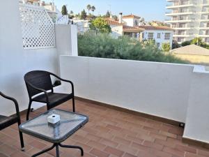 a patio with two chairs and a table on a roof at La Luna Blanca in Torremolinos