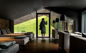 Una mujer parada en una habitación mirando por la ventana en Linder Cycling Hotel, en Selva di Val Gardena