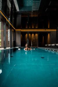 a person swimming in a swimming pool at Linder Cycling Hotel in Selva di Val Gardena