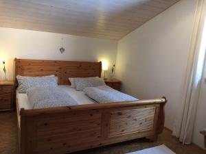 1 dormitorio con 1 cama grande de madera y 2 almohadas en Ferienhaus Spazzacamino, en Bad Grönenbach